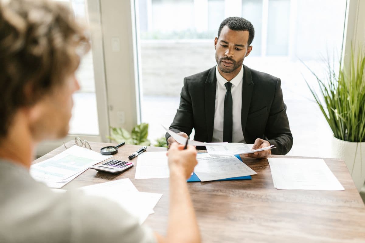 An advisor reviewing paperwork with a client at a desk